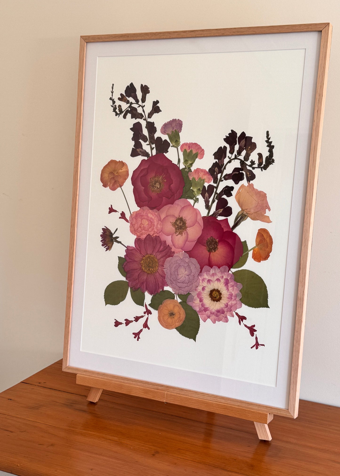Bright pink pressed roses and dahlias pressed and turned into fine art