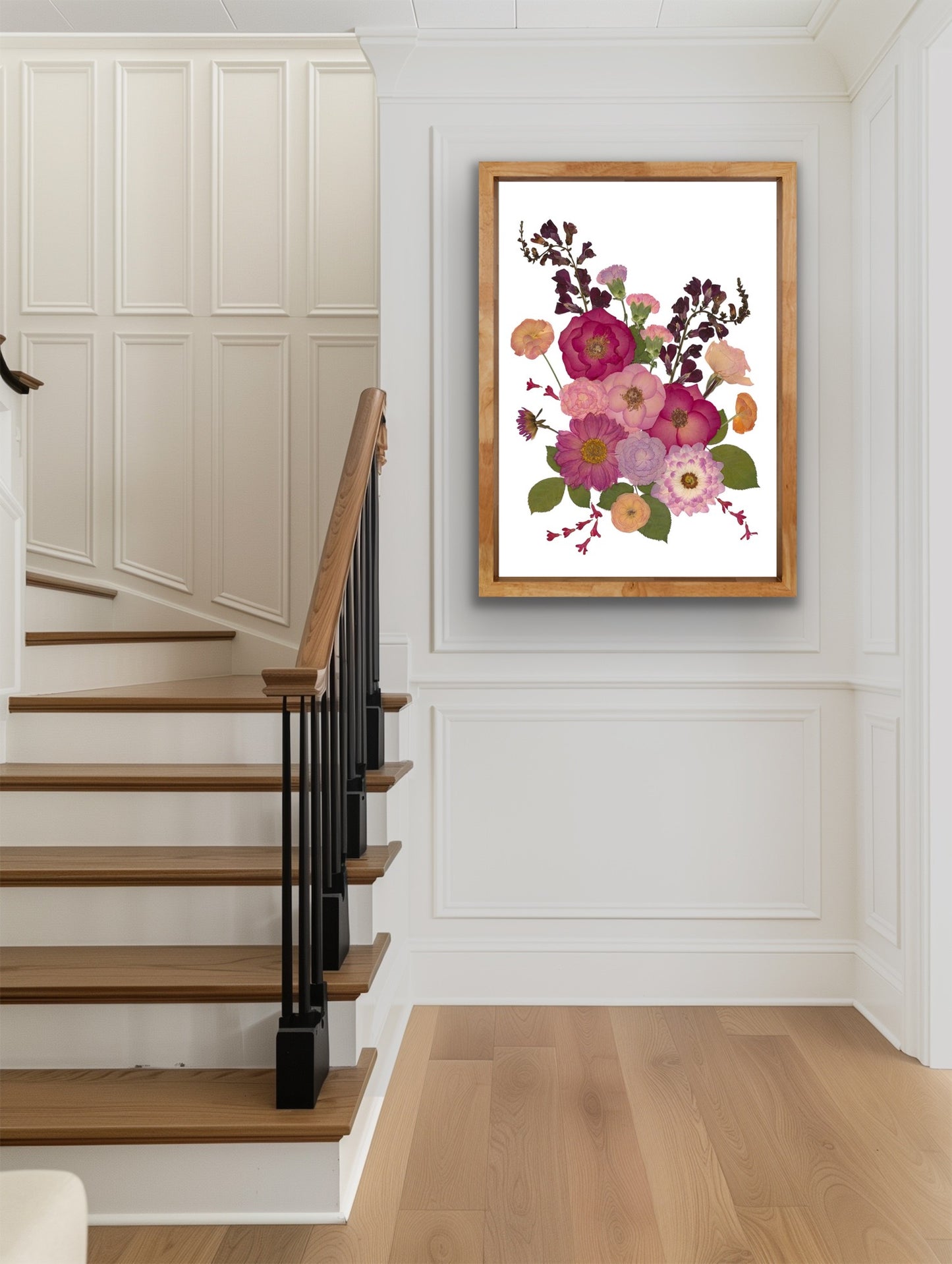 Floral pressed flower artwork in a wooden frame on a wall above a staircase