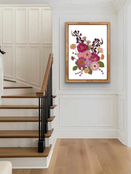 Floral pressed flower artwork in a wooden frame on a wall above a staircase