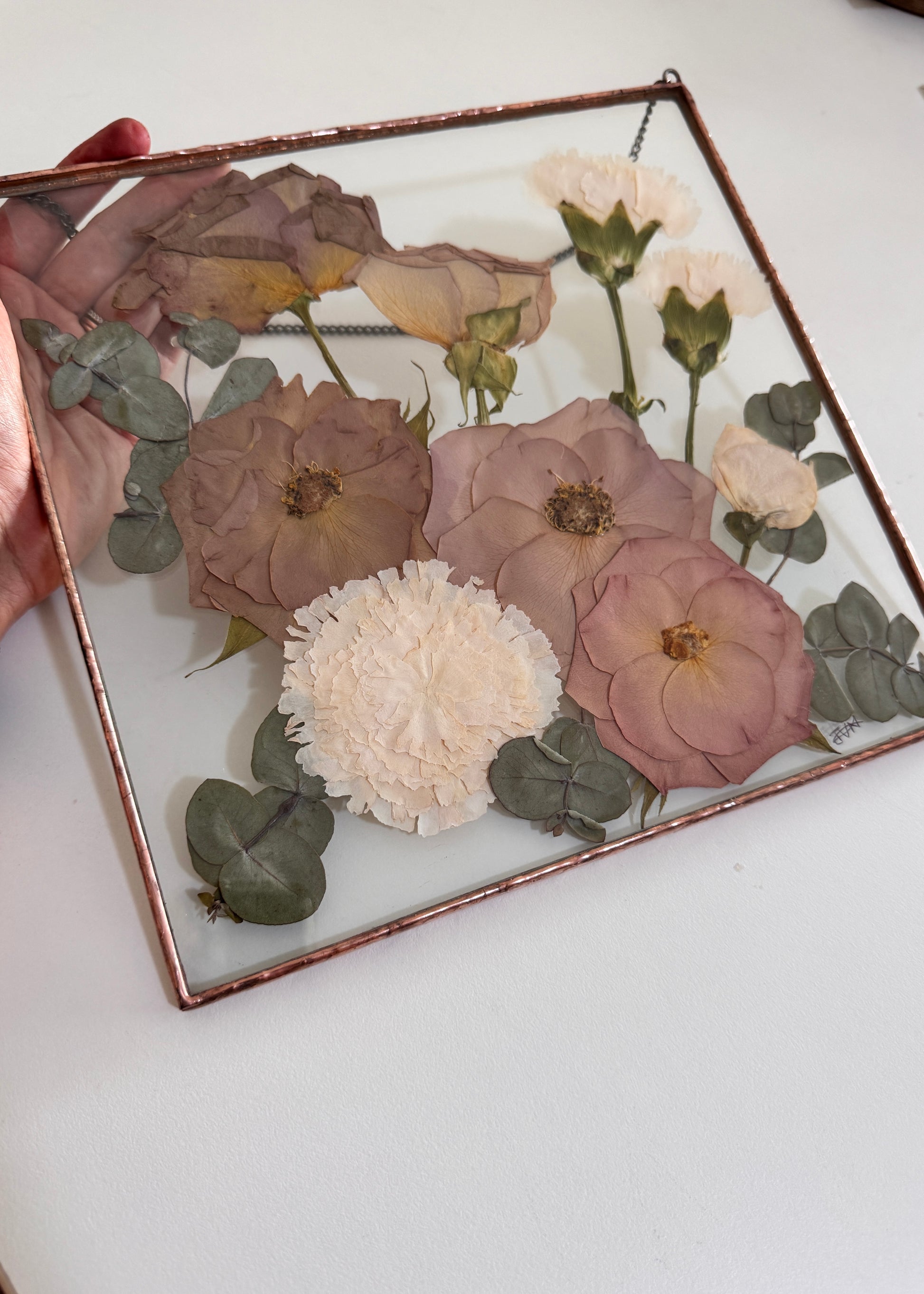 Pressed flowers between glass in soldered metal frame