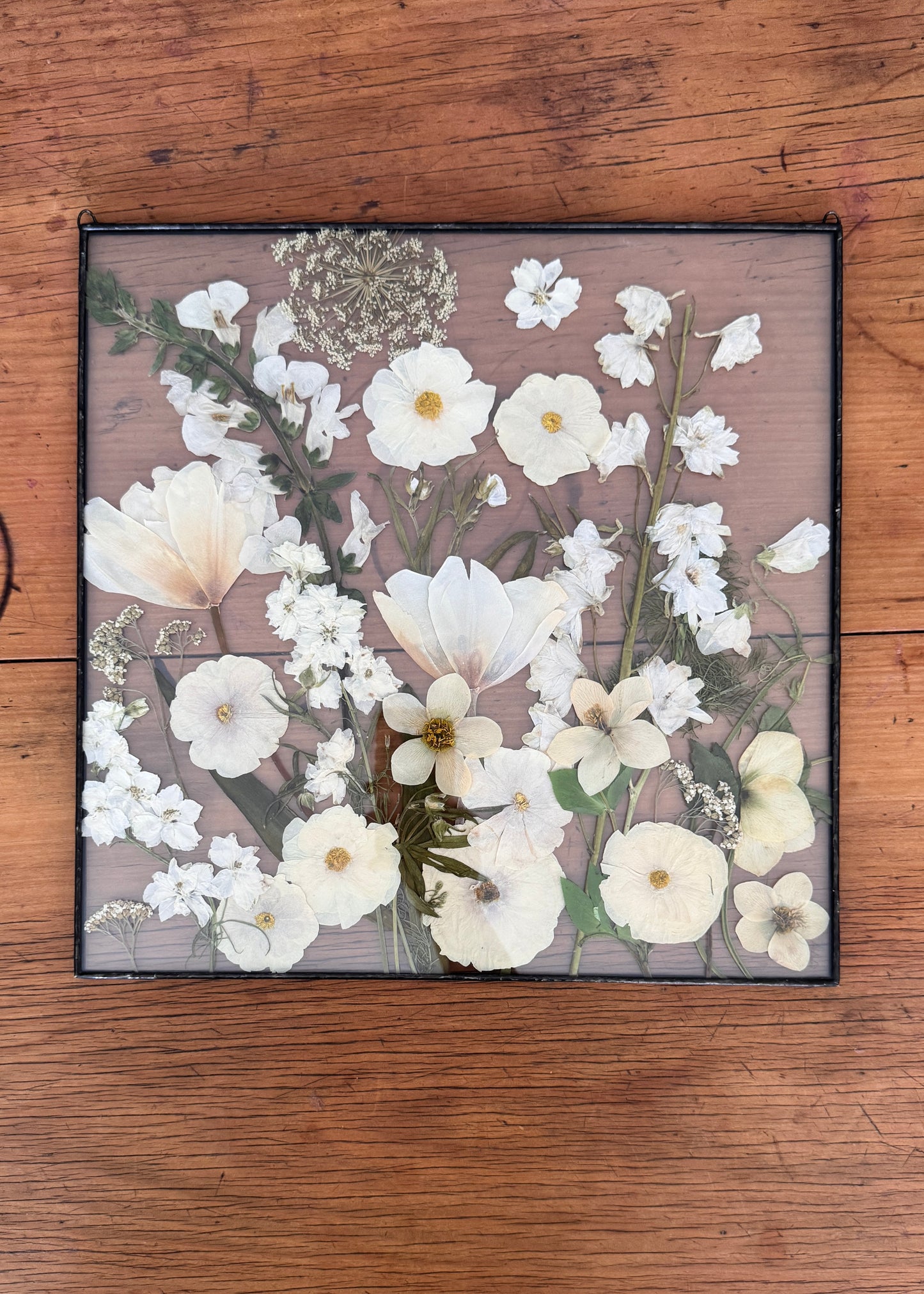 white bouquet pressed and framed in square frame