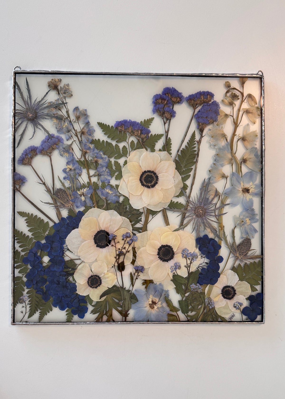 Blue and white wedding flowers framed in square frame