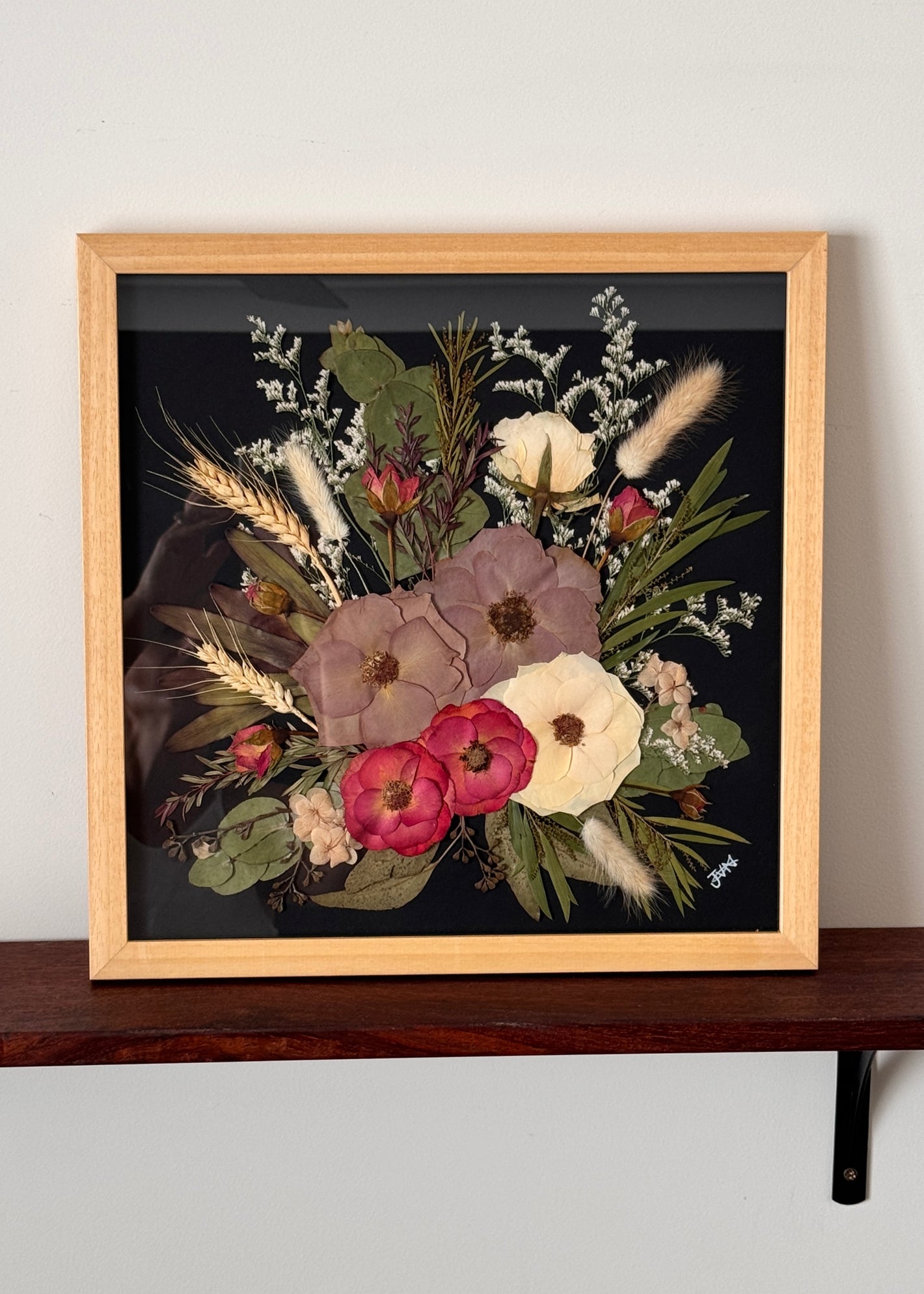 Timber framed pressed flower art on black background