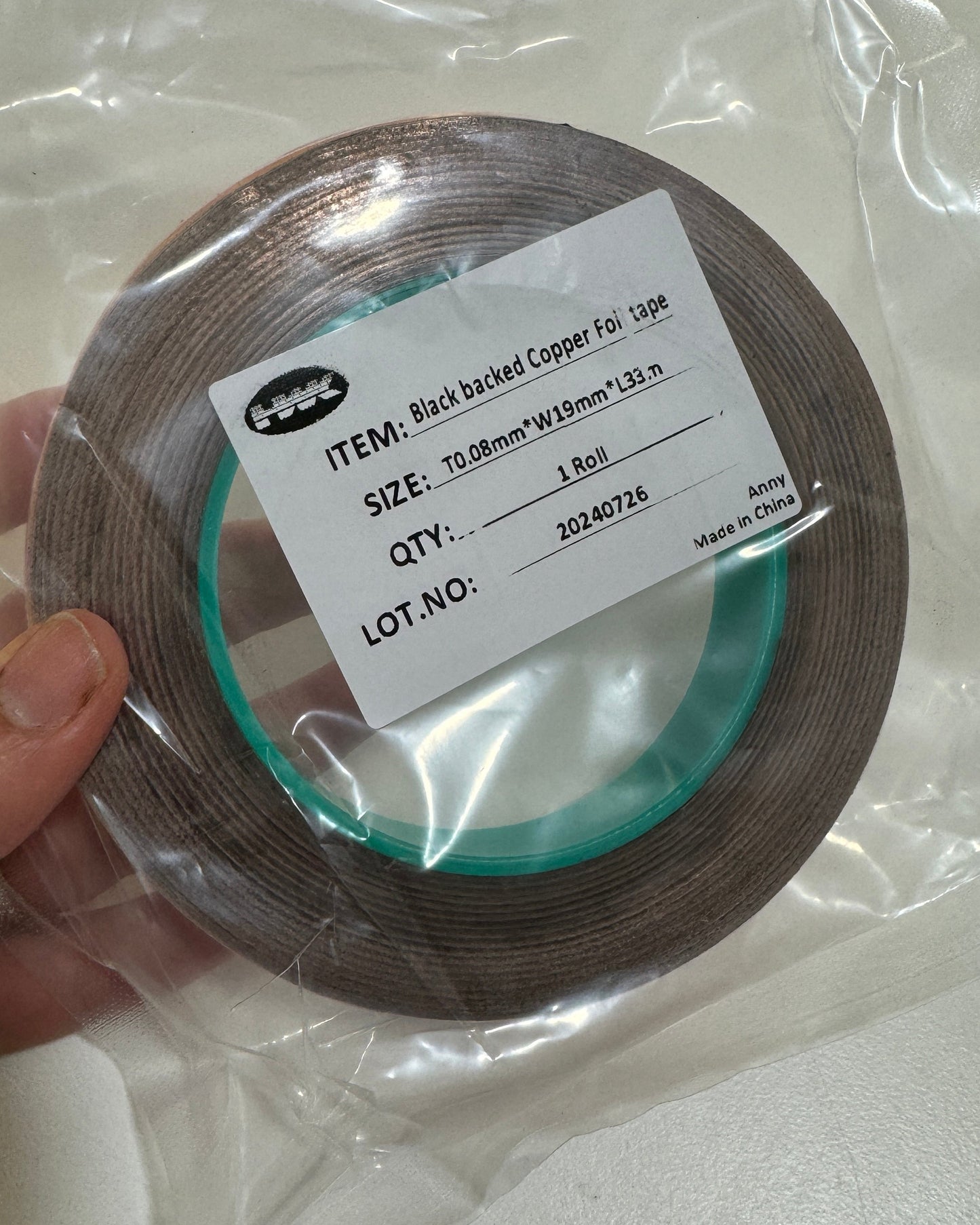 Roll of black backed copper foil tape with a label on a white background