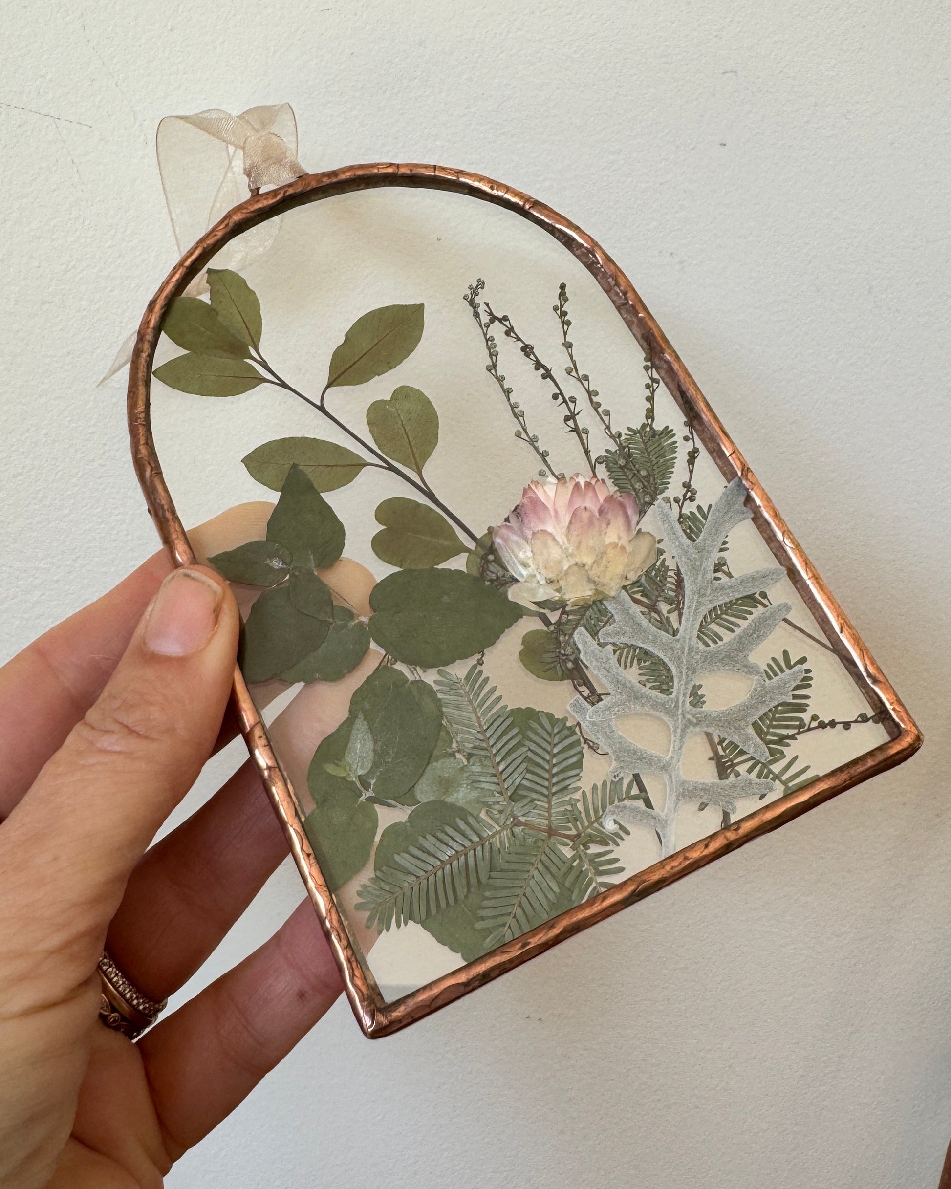 Arched shaped frame with pressed flowers between glass