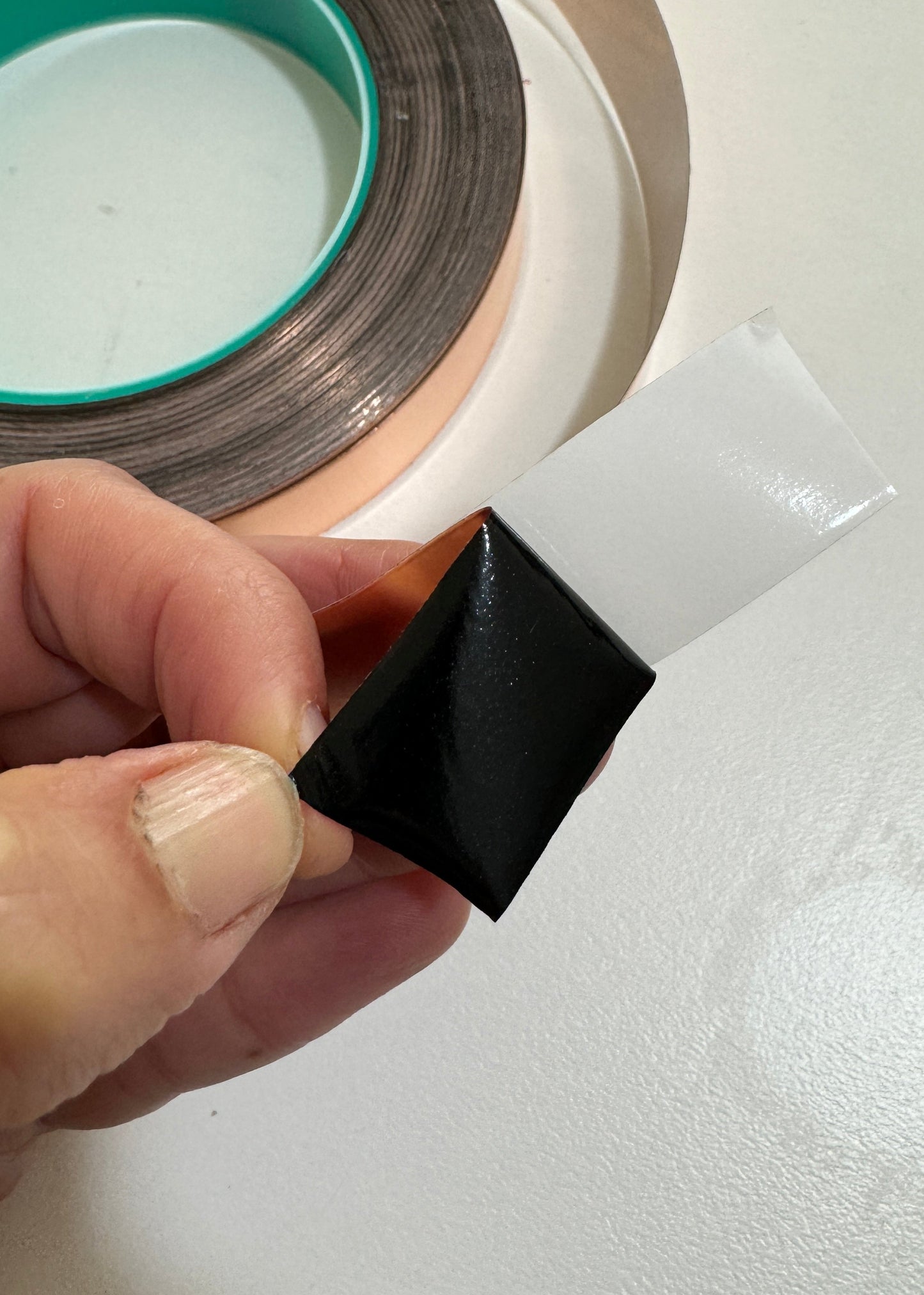 Person showing black backed 12mm copperfoil for stained glassing